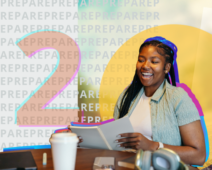 Young woman at desk with notebook in hand smiling.
